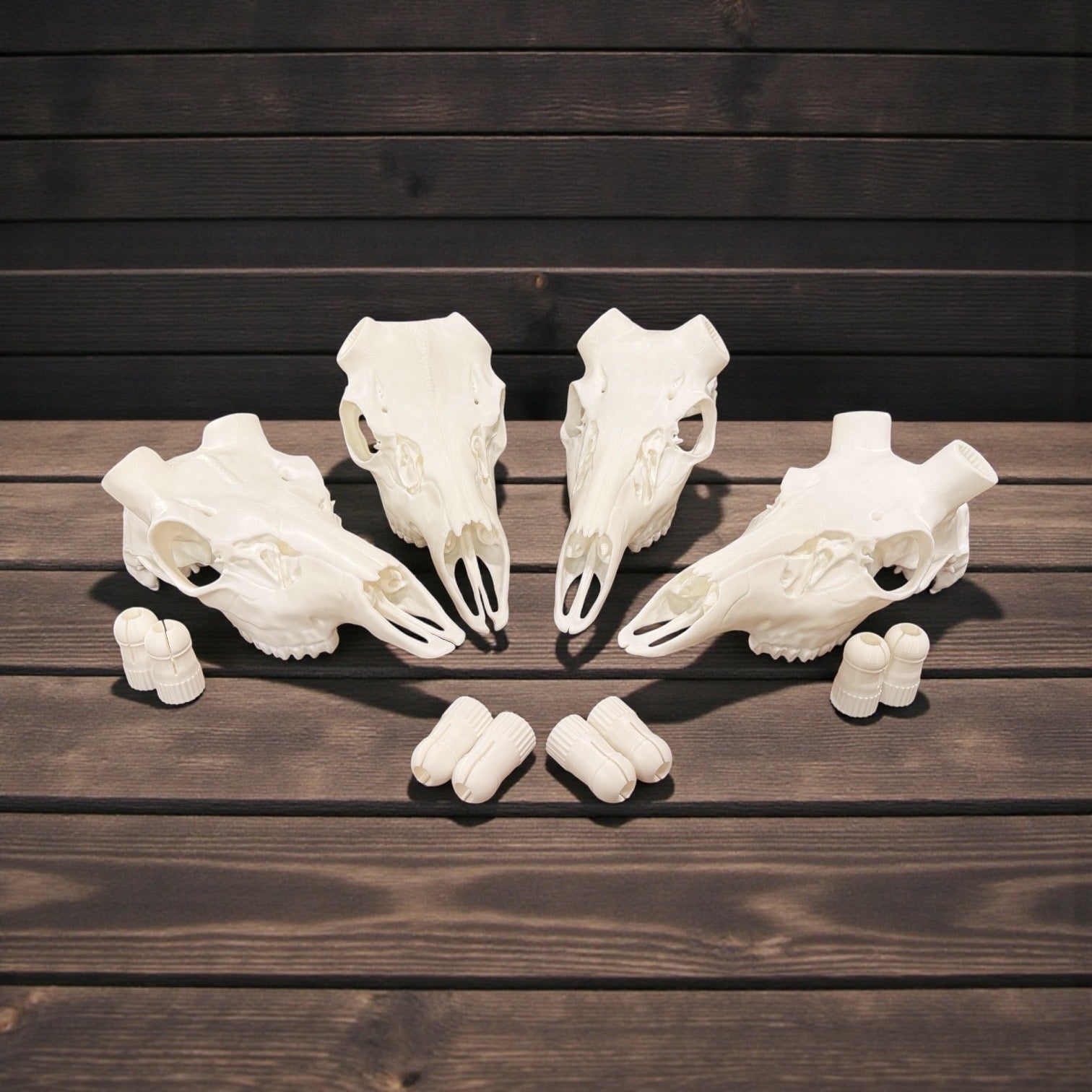 Four 3D-printed deer skull mounts with Bullet Lock connectors arranged on weathered wood